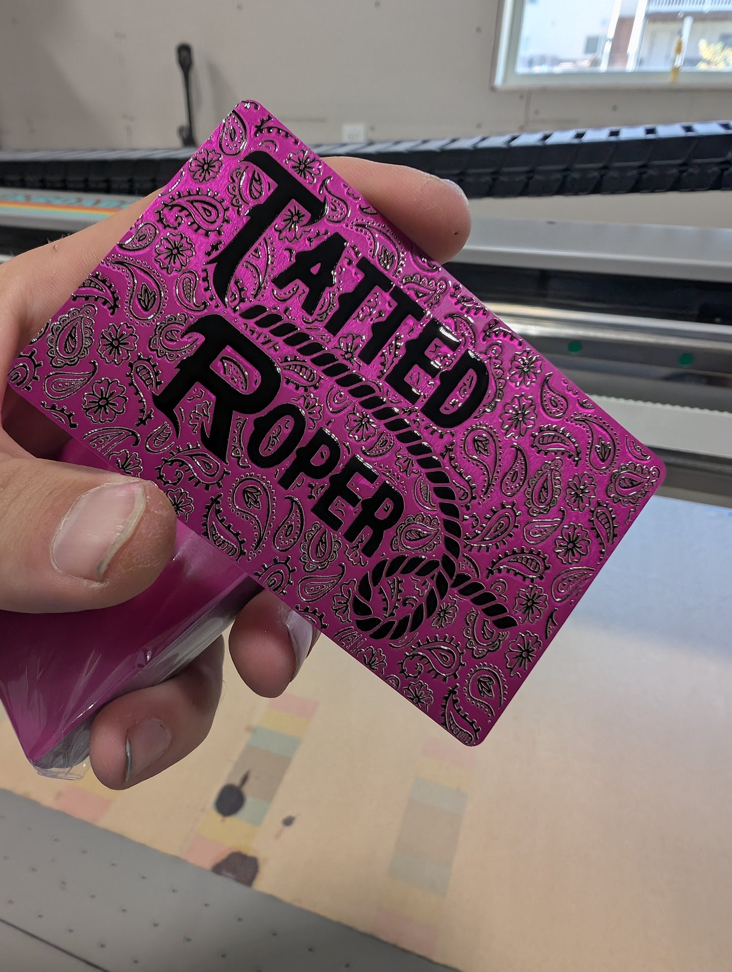 Pink playing card with 'Tatted Proper' text held by a hand.