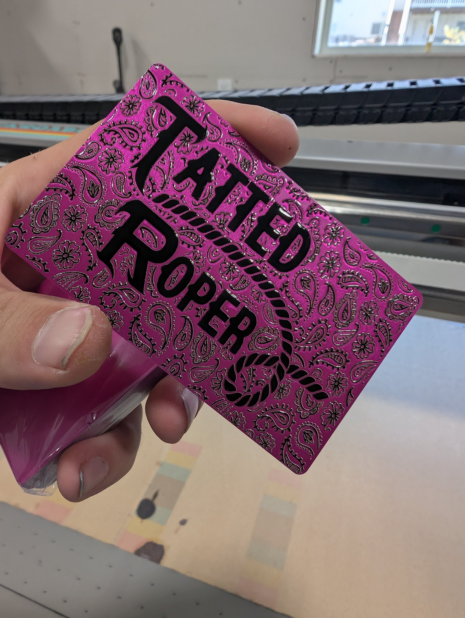 Pink playing card with 'Tatted Proper' text held by a hand.