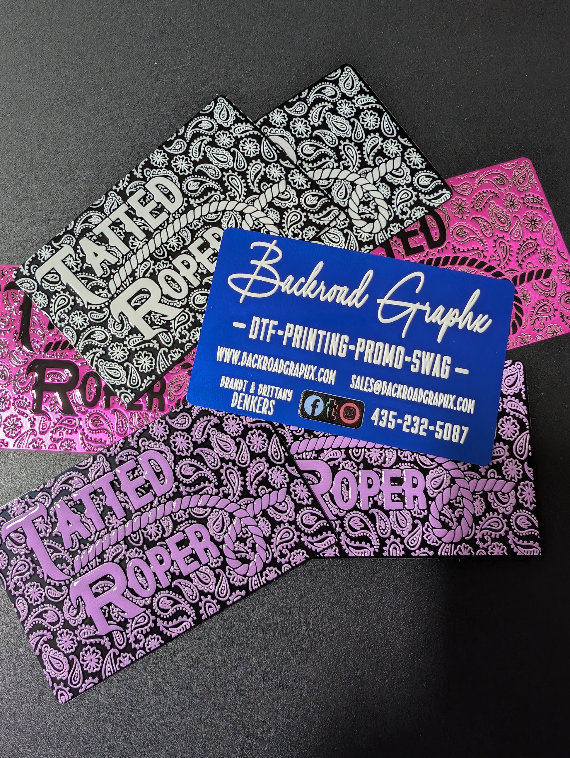 Colorful bandana-style business cards with 'Backroad Graphics' branding on a black background.